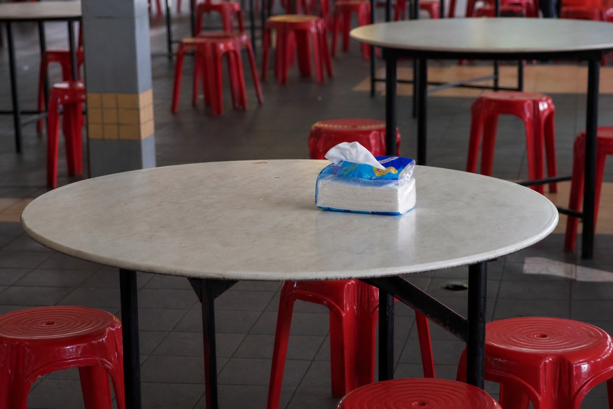 A packet of tissues reserving a hawker centre table, the local "chope" custom