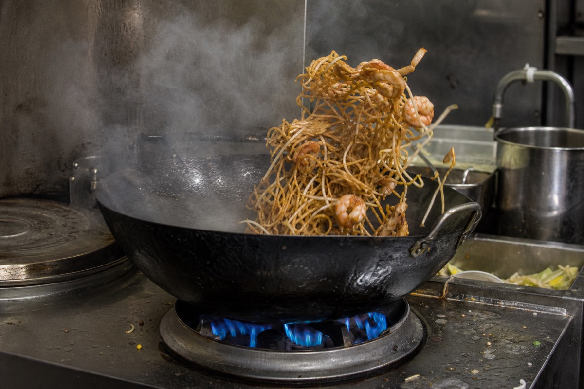 A hawker stall wok over high heat